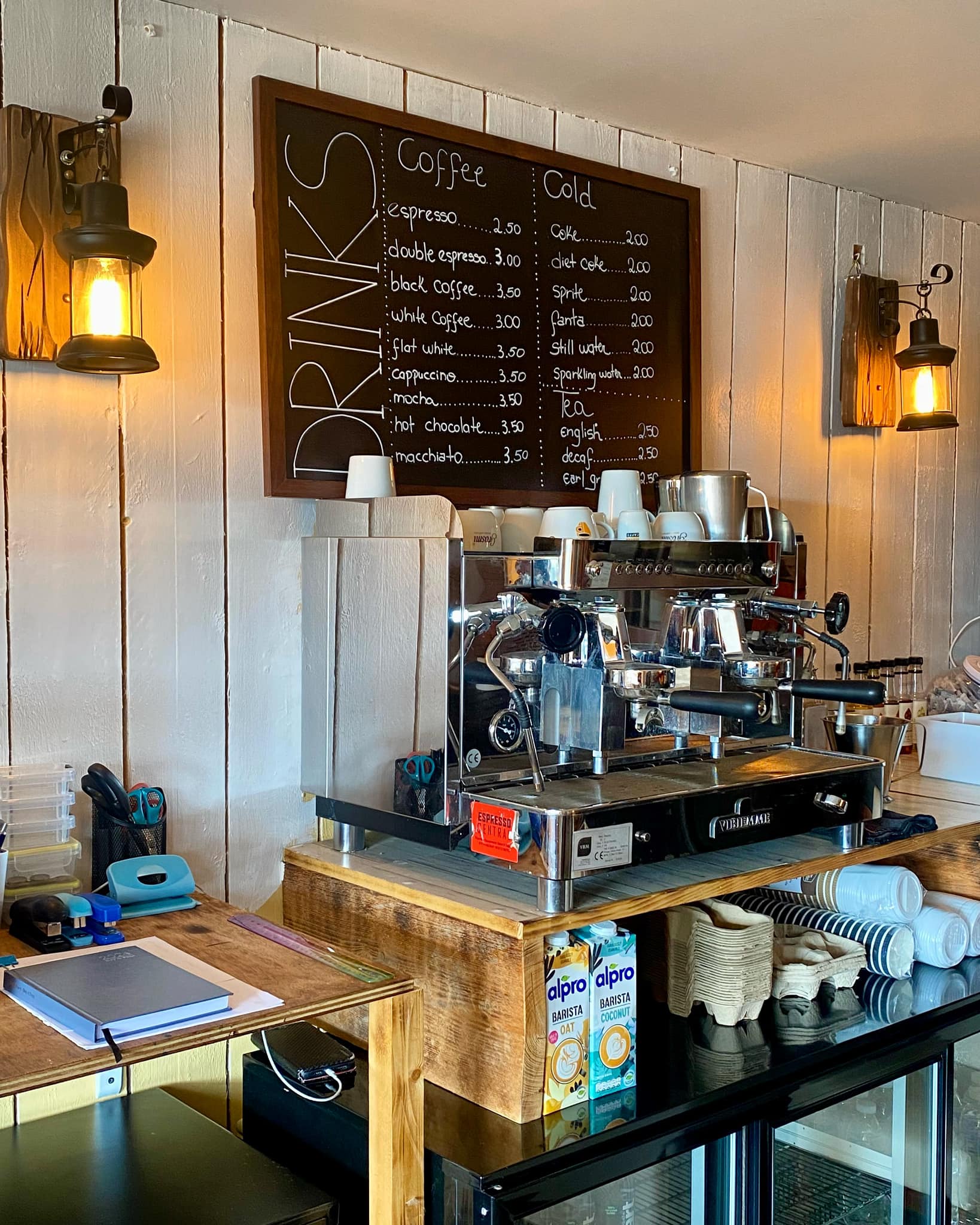 The cozy coffee bar at Pecorino featuring a rustic wooden counter and a chalkboard menu